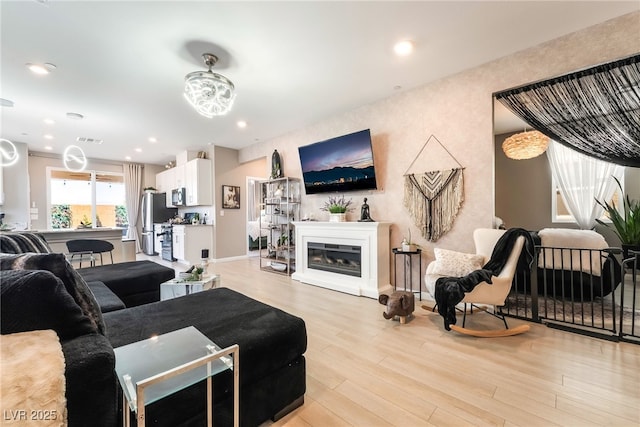 2845 Mincio St, Henderson, NV 89044 - living area featuring light wood-type flooring, a glass covered fireplace, and recessed lighting