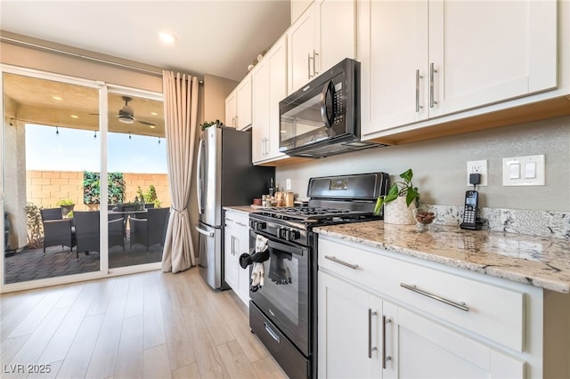 2845 Mincio St, Henderson, NV 89044 - kitchen featuring black appliances, white cabinets, light wood finished floors, and ceiling fan
