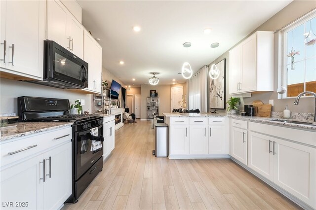 2845 Mincio St, Henderson, NV 89044 - kitchen featuring black appliances, white cabinets, a peninsula, recessed lighting, and light wood-style flooring
