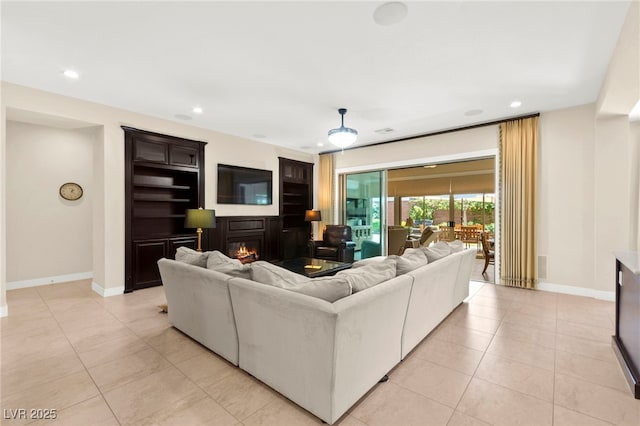 6810 Silver Crescent St, Las Vegas, NV 89148 - living room featuring recessed lighting, light tile patterned floors, and a glass covered fireplace