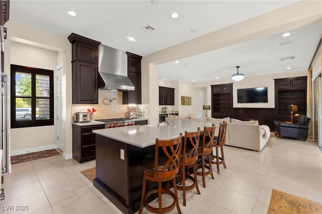 6810 Silver Crescent St, Las Vegas, NV 89148 - kitchen featuring wall chimney exhaust hood, light countertops, decorative backsplash, recessed lighting, and a breakfast bar