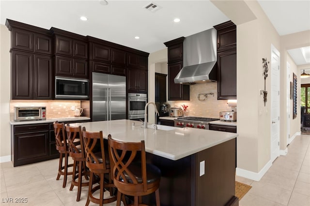 6810 Silver Crescent St, Las Vegas, NV 89148 - kitchen featuring wall chimney range hood, appliances with stainless steel finishes, light countertops, light tile patterned floors, and recessed lighting