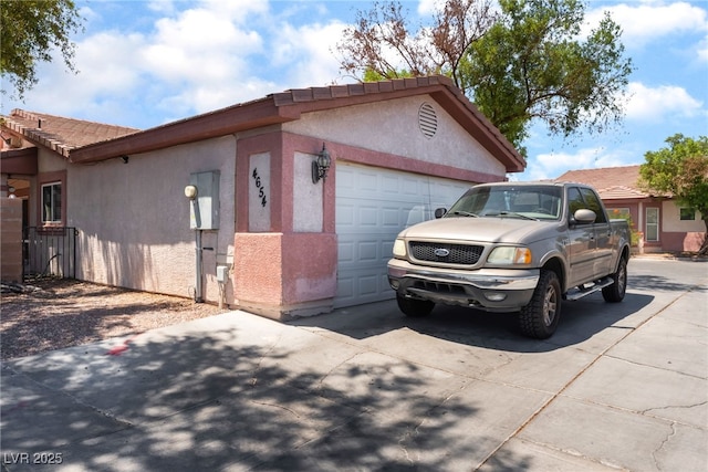 4656 E Desert Inn Rd, Las Vegas, NV 89121 - view of side of home featuring stucco siding, concrete driveway, and an attached garage