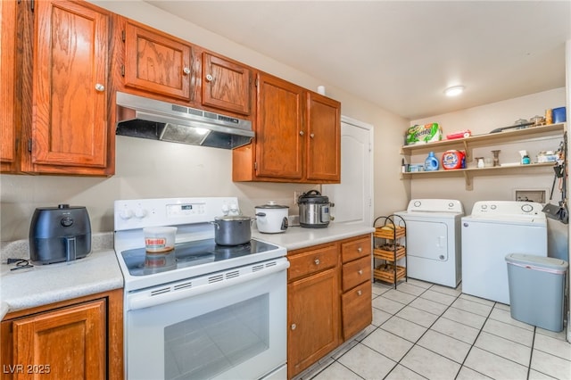 4656 E Desert Inn Rd, Las Vegas, NV 89121 - kitchen with white electric range, under cabinet range hood, washing machine and clothes dryer, light countertops, and light tile patterned floors