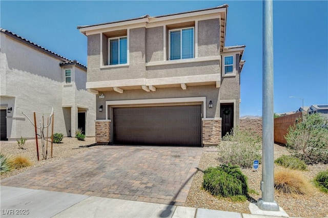 4240 Spring Storm Ave, North Las Vegas, NV 89081 - view of front of house featuring stucco siding, a garage, decorative driveway, and stone siding
