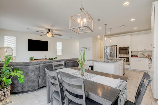 4240 Spring Storm Ave, North Las Vegas, NV 89081 - dining room featuring healthy amount of natural light, ceiling fan, light tile patterned floors, recessed lighting, and a chandelier