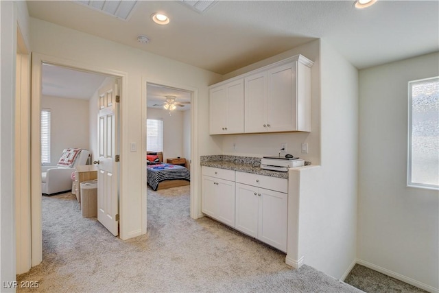 4240 Spring Storm Ave, North Las Vegas, NV 89081 - kitchen with light carpet, white cabinetry, and recessed lighting