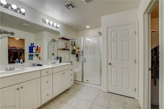 4240 Spring Storm Ave, North Las Vegas, NV 89081 - bathroom featuring a walk in closet, a stall shower, tile patterned floors, and double vanity