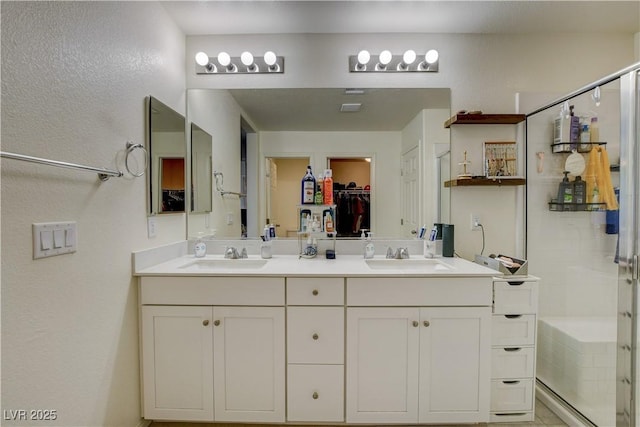 4240 Spring Storm Ave, North Las Vegas, NV 89081 - full bathroom featuring double vanity, an enclosed shower, a walk in closet, and a textured wall