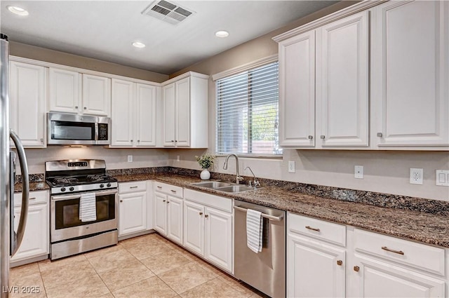 7704 Lots Hills Dr, Las Vegas, NV 89179 - kitchen featuring appliances with stainless steel finishes, white cabinets, recessed lighting, light tile patterned floors, and dark stone countertops