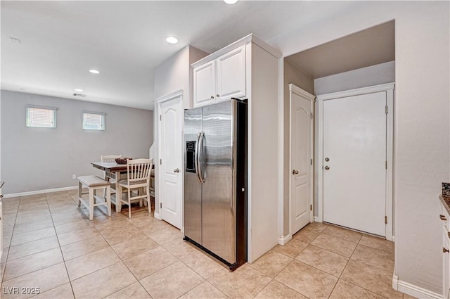 7704 Lots Hills Dr, Las Vegas, NV 89179 - kitchen with stainless steel refrigerator with ice dispenser, light tile patterned floors, white cabinetry, and recessed lighting