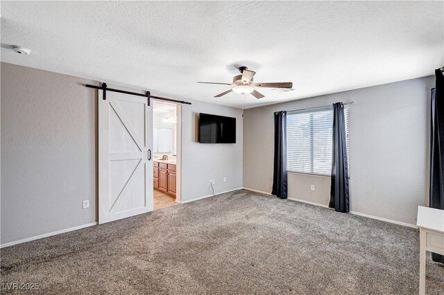 7704 Lots Hills Dr, Las Vegas, NV 89179 - unfurnished bedroom with light colored carpet, a barn door, a textured ceiling, connected bathroom, and a ceiling fan