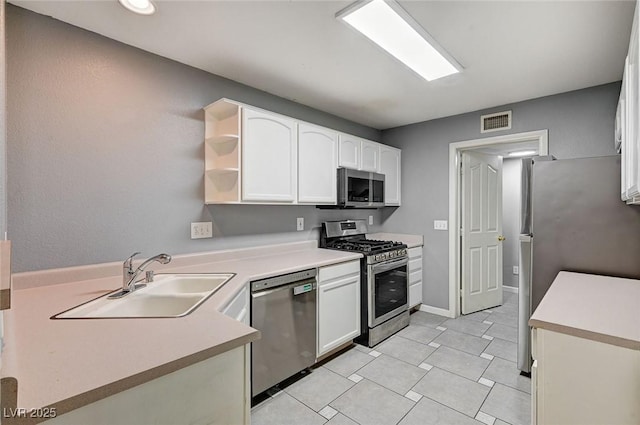 198 Winterport St, Henderson, NV 89074 - kitchen with appliances with stainless steel finishes, white cabinets, open shelves, light countertops, and light tile patterned floors
