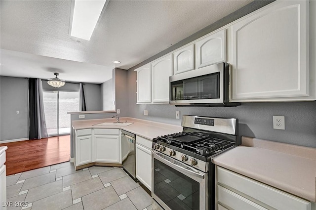198 Winterport St, Henderson, NV 89074 - kitchen with stainless steel appliances, white cabinets, light countertops, light tile patterned floors, and a peninsula