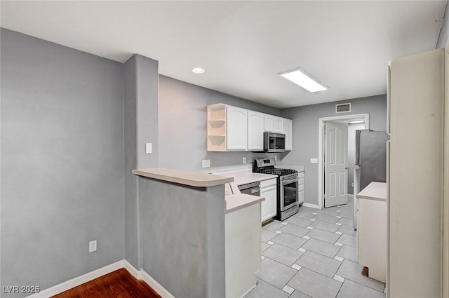 198 Winterport St, Henderson, NV 89074 - kitchen featuring appliances with stainless steel finishes, open shelves, white cabinets, light countertops, and a peninsula