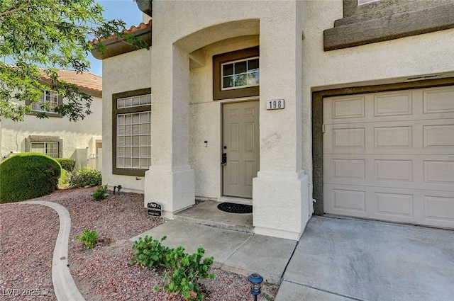 198 Winterport St, Henderson, NV 89074 - property entrance featuring stucco siding, concrete driveway, and a tiled roof