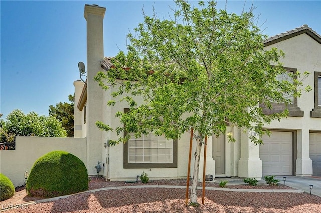 198 Winterport St, Henderson, NV 89074 - view of front facade with stucco siding, a garage, driveway, and a tiled roof