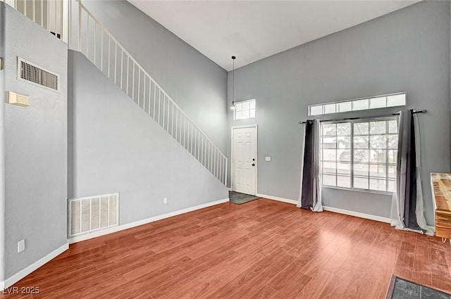 198 Winterport St, Henderson, NV 89074 - unfurnished living room featuring a towering ceiling, wood finished floors, and stairway