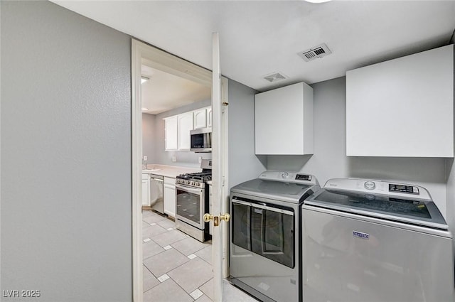 198 Winterport St, Henderson, NV 89074 - laundry area with washer and clothes dryer, cabinet space, and light tile patterned floors