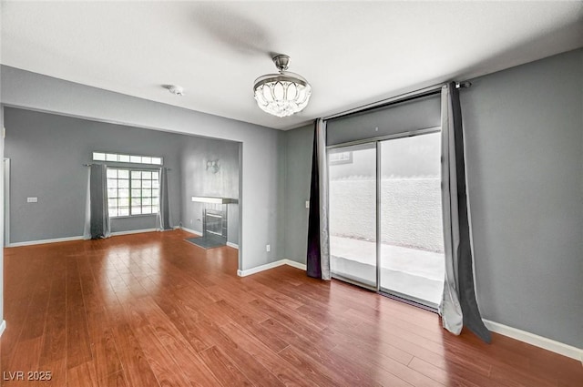 198 Winterport St, Henderson, NV 89074 - unfurnished living room with wood finished floors, a chandelier, and a fireplace with flush hearth