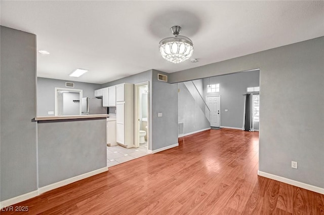 198 Winterport St, Henderson, NV 89074 - unfurnished living room with a chandelier, light wood-style floors, and stairway