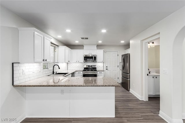 9006 Cedar Door Ave, Las Vegas, NV 89148 - kitchen featuring stainless steel appliances, a peninsula, backsplash, dark wood-type flooring, and recessed lighting