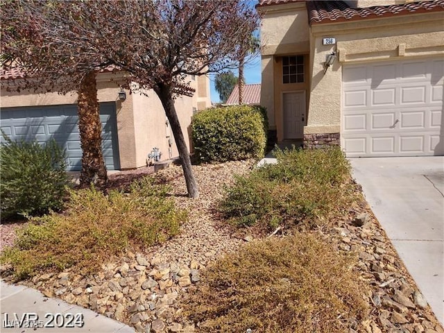 256 Camino Viejo St, Henderson, NV 89012 - view of property exterior with stucco siding, a tiled roof, an attached garage, concrete driveway, and stone siding