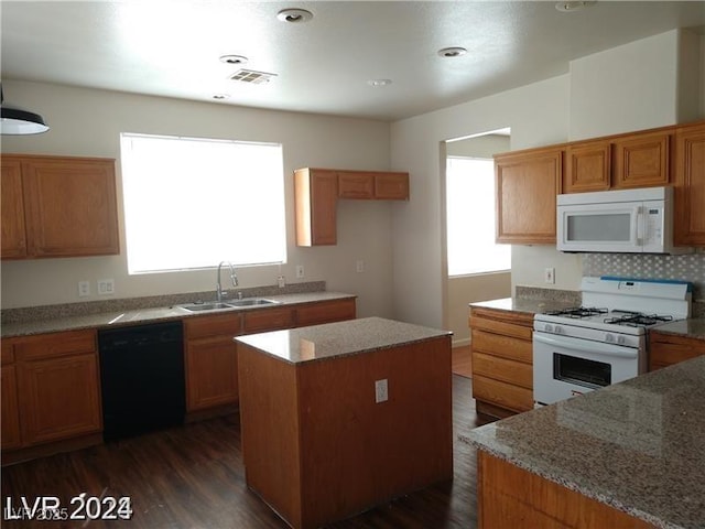 256 Camino Viejo St, Henderson, NV 89012 - kitchen with white appliances, a center island, dark wood finished floors, light stone counters, and brown cabinets