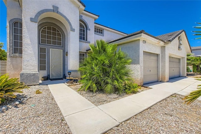 5409 Flora Spray St, Las Vegas, NV 89130 - view of front of property with stucco siding, an attached garage, and concrete driveway
