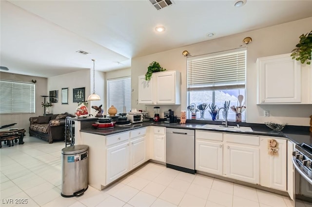 5409 Flora Spray St, Las Vegas, NV 89130 - kitchen with appliances with stainless steel finishes, dark countertops, a peninsula, open floor plan, and white cabinets