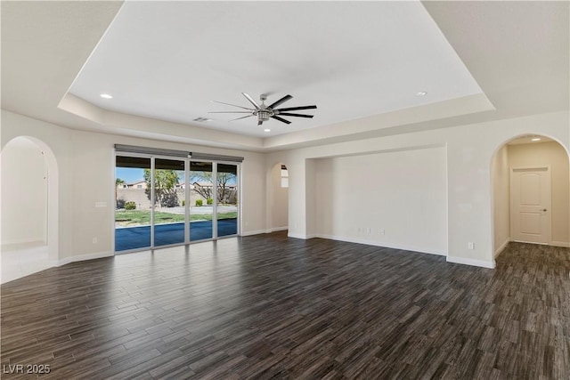 9240 Northfield Park Ct, Las Vegas, NV 89148 - unfurnished living room with a tray ceiling, arched walkways, a ceiling fan, dark wood-type flooring, and recessed lighting