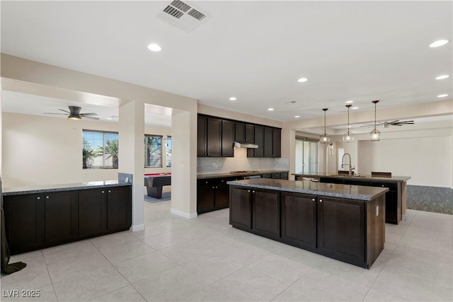 9240 Northfield Park Ct, Las Vegas, NV 89148 - kitchen with an island with sink, under cabinet range hood, backsplash, recessed lighting, and ceiling fan