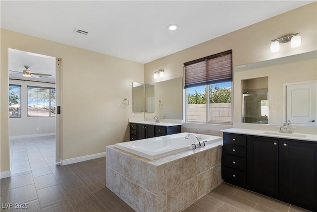 9240 Northfield Park Ct, Las Vegas, NV 89148 - full bathroom featuring two vanities, a garden tub, a stall shower, a ceiling fan, and tile patterned flooring