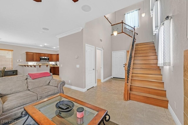 10601 Lessona St, Las Vegas, NV 89141 - living room with stairway, light tile patterned flooring, crown molding, and ceiling fan