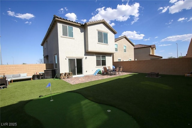 7037 Tilligerry St, North Las Vegas, NV 89084 - back of house with a putting green, a fenced backyard, outdoor lounge area, stucco siding, and a patio