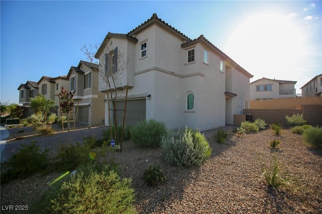 7037 Tilligerry St, North Las Vegas, NV 89084 - view of home's exterior featuring a garage, stucco siding, and a tiled roof