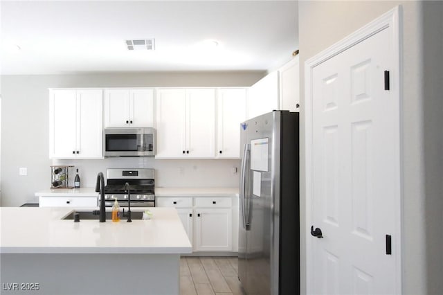 7037 Tilligerry St, North Las Vegas, NV 89084 - kitchen with appliances with stainless steel finishes, white cabinets, and light countertops