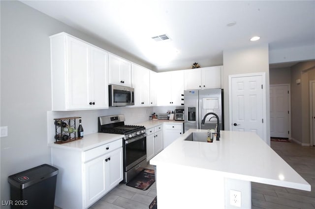 7037 Tilligerry St, North Las Vegas, NV 89084 - kitchen with stainless steel appliances, a center island with sink, light countertops, white cabinets, and recessed lighting