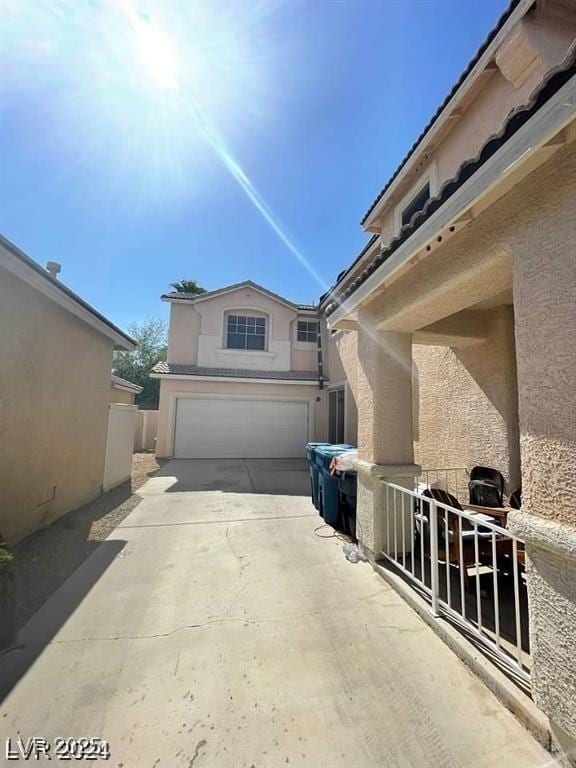 9801 Bradford Summit St, Las Vegas, NV 89183 - view of side of property with stucco siding, an attached garage, and driveway