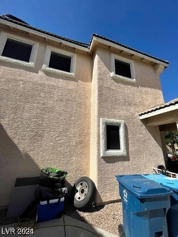 9801 Bradford Summit St, Las Vegas, NV 89183 - view of side of home with stucco siding and a tile roof
