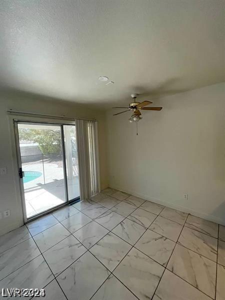 9617 Pine River Ln, Las Vegas, NV 89123 - spare room featuring light marble finish flooring and a ceiling fan