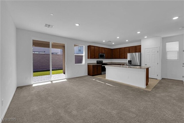 5677 Asyma Ct, Las Vegas, NV 89113 - kitchen featuring stainless steel appliances, light carpet, healthy amount of natural light, recessed lighting, and a kitchen island with sink