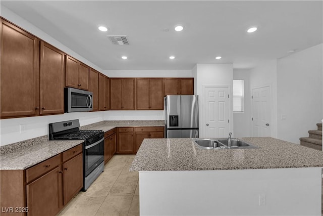 5677 Asyma Ct, Las Vegas, NV 89113 - kitchen featuring stainless steel appliances, light tile patterned flooring, a center island with sink, recessed lighting, and light stone counters