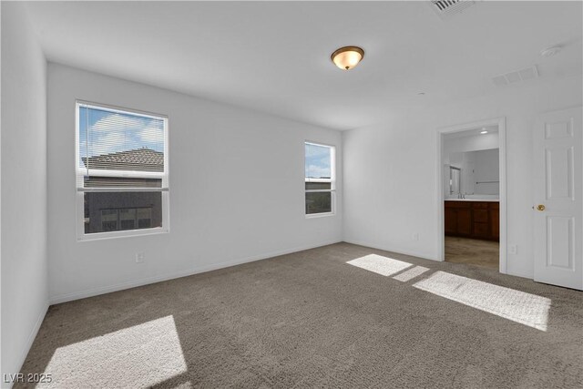 5677 Asyma Ct, Las Vegas, NV 89113 - unfurnished bedroom with carpet, multiple windows, and connected bathroom