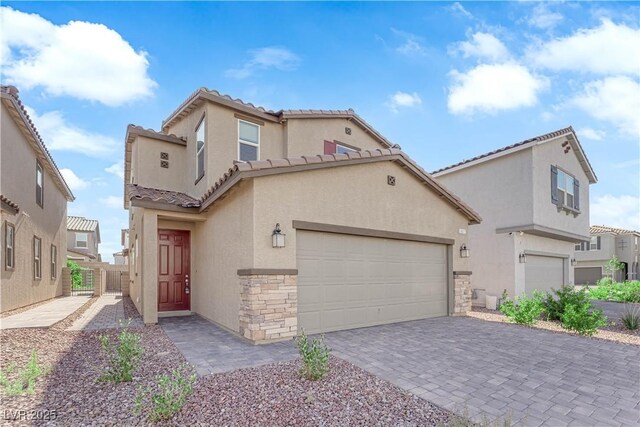 5677 Asyma Ct, Las Vegas, NV 89113 - mediterranean / spanish home featuring stucco siding, stone siding, a tile roof, and decorative driveway