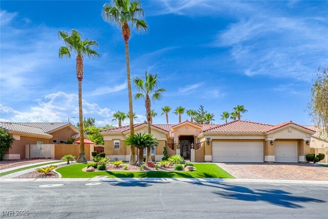 7311 Chaparral Cove Ln, Las Vegas, NV 89131 - mediterranean / spanish home with stucco siding, a garage, a tile roof, and driveway