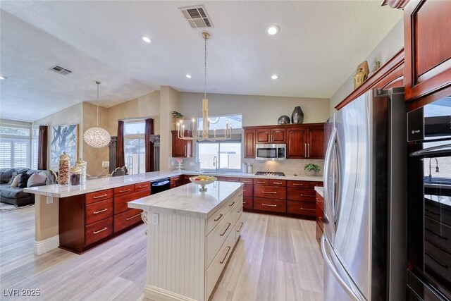 7311 Chaparral Cove Ln, Las Vegas, NV 89131 - kitchen featuring appliances with stainless steel finishes, vaulted ceiling, light countertops, a peninsula, and healthy amount of natural light