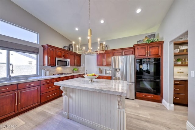 7311 Chaparral Cove Ln, Las Vegas, NV 89131 - kitchen with appliances with stainless steel finishes, a chandelier, light wood finished floors, a kitchen island, and backsplash
