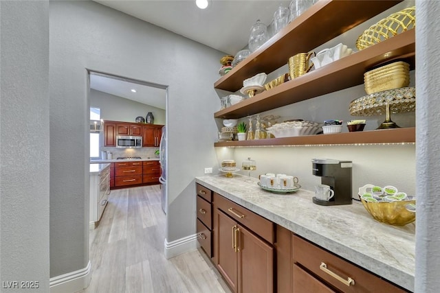 7311 Chaparral Cove Ln, Las Vegas, NV 89131 - bar with appliances with stainless steel finishes, light wood-type flooring, recessed lighting, tasteful backsplash, and lofted ceiling