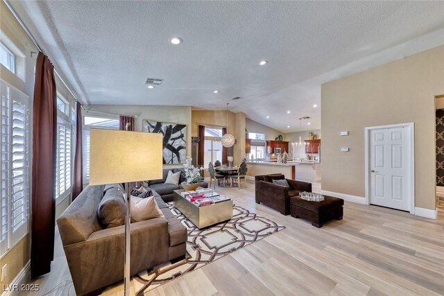 7311 Chaparral Cove Ln, Las Vegas, NV 89131 - living area featuring a textured ceiling, vaulted ceiling, light wood-style floors, and recessed lighting